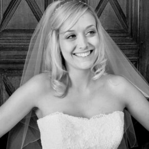 The bride strikes a pose against a wood panelled backdrop at her Dorton House wedding