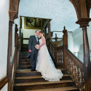 The newlyweds pose on the staircase for this formal shot at their Dorton House wedding