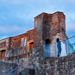 Dramatic photography pose of the newlyweds on their wedding day at the summit of Farnham Castle captured during golden hour after a climb up the many steps