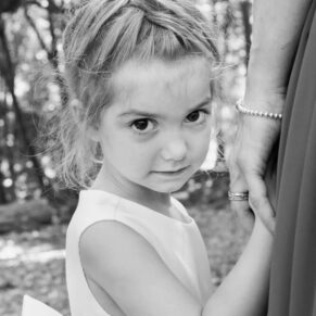 Shy flower girl posing for the camera just before the woodland ceremony at this Buckinghamshire outdoor civil marriage