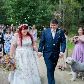 The newlyweds make their way through the confetti aisle at their woodland summer celebrations