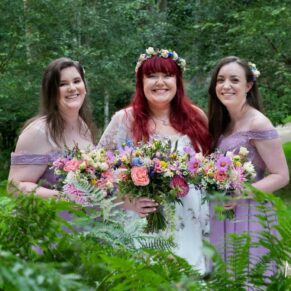 The bride with her bridesmaids in amongst the woodland ferns at her Buckinghamshire marriage reception