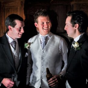 The groom chatting to his best men in the oak panelled Great Hall shortly after the marriage ceremony