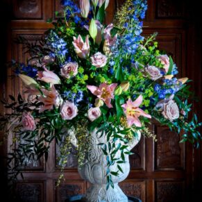 Stunning large floral arrangement captured in the Great Hall against dark oak wood panelling