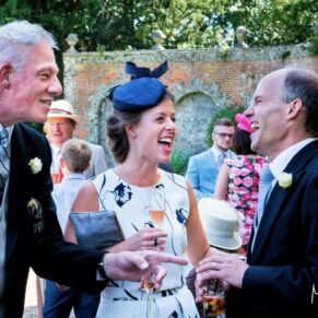 A group of three friends giggling away during this summer drinks reception