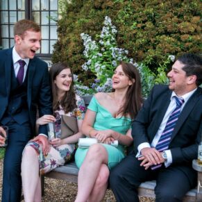 Four guests enjoying the lively banter during the drinks reception in the wonderful gardens