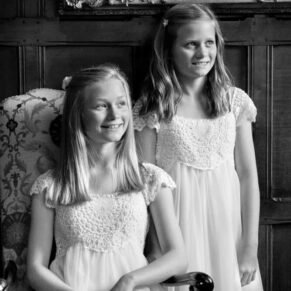 Atmospheric window lit portrait of two young bridesmaids in the Great Hall