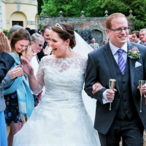 The newlyweds walk through the confetti aisle to loud cheers after their civil ceremony