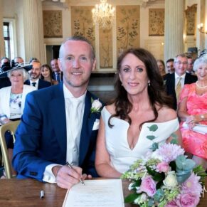 The newlyweds signing the register in the historic Dining Room at their Buckinghamshire venue