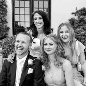 The newlyweds captured in a casual pose with their bridesmaids during the drinks reception