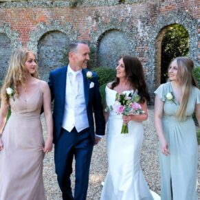 The newlyweds take a relaxed stroll with their bridesmaids at the back of the venue