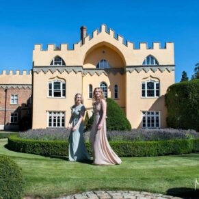 The bridesmaids walking at the front of the venue under perfect blue summer skies