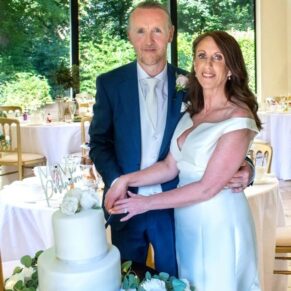 The smiling newlyweds cut the cake inside Hill House on the estate