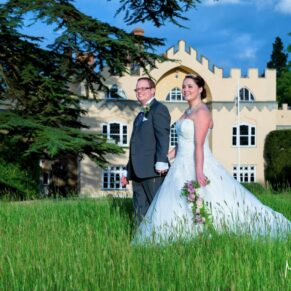 The newlyweds walk through the summer meadow near the front of the property