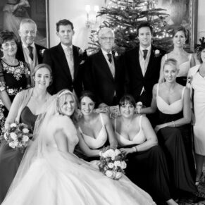 Relaxed family portrait captured indoors next to the gorgeous Christmas tree