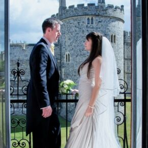 Harte and Garter Hotel Windsor Wedding Photography - the newlyweds captured through a doorway on the venue's balcony