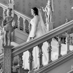 The bride makes her way down the Jacobean staircase on her wedding day at Hartwell House Hotel