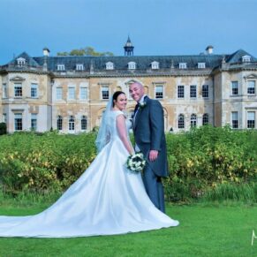 The newlyweds captured on the manicured lawns with Hartwell House behind in the distance
