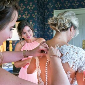 Final gown adjustments for the bride before her Hartwell House wedding ceremony