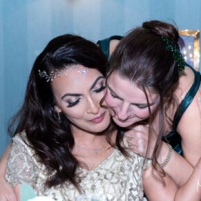A special moment between the bride and her bridesmaid captured at the top table during this wonderful Hartwell House wedding