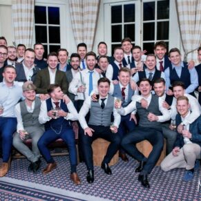 Thirty lively lads casually pose for the camera in the bar of Hedsor House