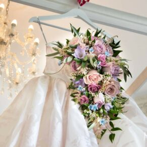 The stunning bouquet together with the bride's highly detailed gown captured hanging from the bed at her Hedsor House wedding