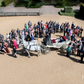 Big wedding group pose of everyone captured from above at the front of Hedsor House