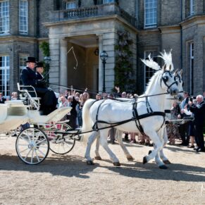 The horse and carriage with its newly married passengers are waved off by the guests at this Hedsor House summer wedding