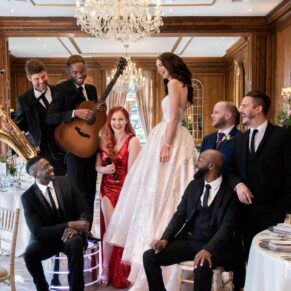 The newlyweds strike a pose with the Function Band in the dining room at their Hedsor House wedding