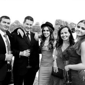 Casual group pose of a group of friends captured during the wedding drinks reception at Hedsor House