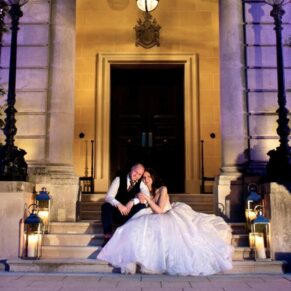 Atmospheric candle lighting for this romantic wedding pose of the newlyweds at the front door entrance to Hedsor House