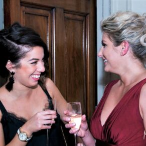 Candid image of two ladies having a giggle during the indoor drinks reception