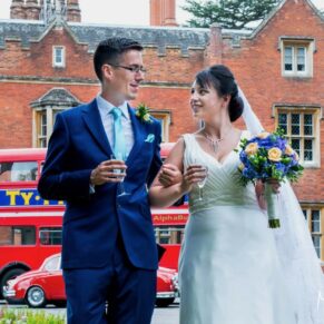 The newlyweds take a stroll with their London red bus behind during their Latimer Estate summer wedding