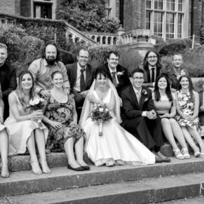 Photography of the bride and groom with some friends on the grand outdoor steps of Latimer Estate on their wedding day