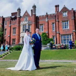 The happy newlyweds taking a stroll in the grounds of the Latimer Estate with the main house behind theme