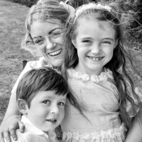 Photography of one of the wedding guest's cuddles up to her children in the gardens of the Latimer Estate