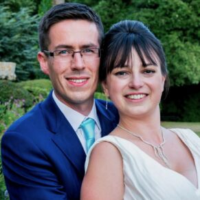 The newlyweds in a close-up pose in the gardens of their summer reception venue