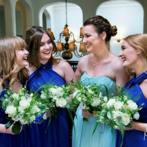 The bridesmaids enjoy a giggle at the top of the stairs just before the marriage ceremony