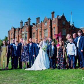 Family group pose with the historic Latimer Estate in the distance for this summer celebration