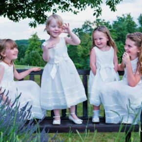 The flower girls larking around on a bench during the drinks reception at this Latimer Estate wedding