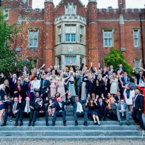 Large group pose on the grand steps within the gardens of the Latimer Estate