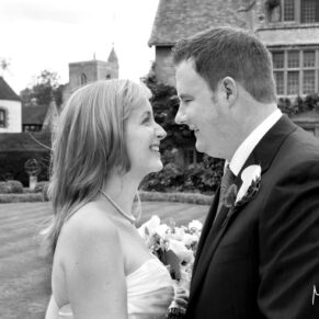 The bride and groom giggle at one another in the gardens at their Le Manoir Aux Quat Saisons wedding