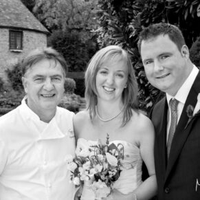 Raymond Blanc joins the bride and groom for a photograph in the gardens of Le Manoir Aux Quat Saisons