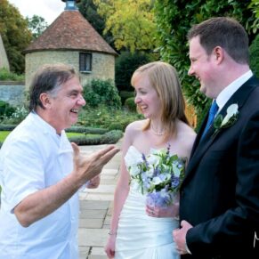 The newly married couple meet Raymond Blanc in the gardens at their Le Manoir Aux Quat Saisons wedding