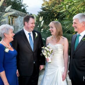 An informal moment between the newlyweds and their parents during the drinks reception at this Le Manoir Aux Quat Saisons wedding