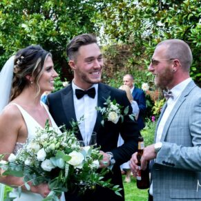 Candid shot of the newlyweds with a friend captured during the lively drinks reception