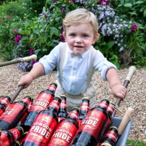 The cheeky pageboy has decided that he's in charge of the beer for the day during this Old Windsor drinks reception