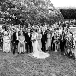 Big group shot of all the guests in the stunning walled gardens at this gorgeous outdoor venue