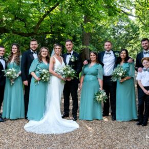 The bridal party pose for the camera in the gorgeous gardens of their reception venue