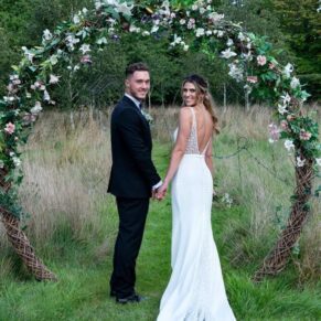 The newlyweds pose for a picture under the flower arch in the fabulous gardens at this Old Windsor venue